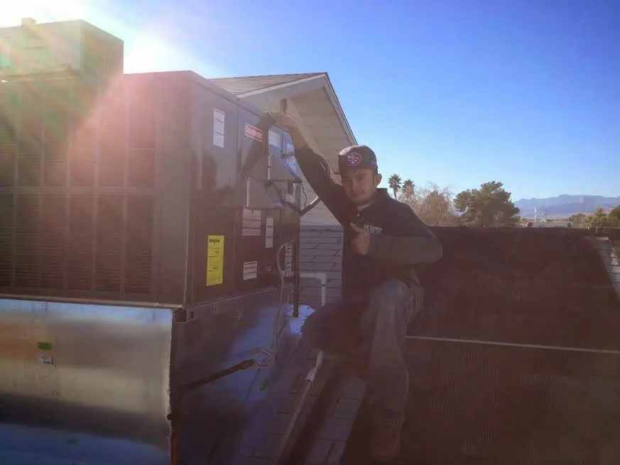 HVAC technician performing Boiler Repair on a rooftop unit in Latrobe